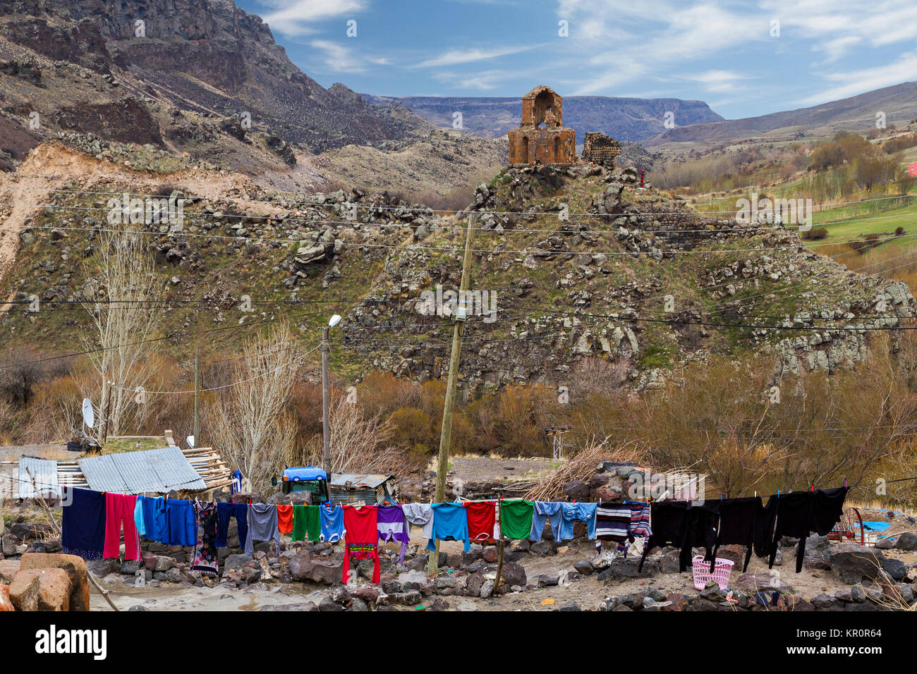 Colorful laundry in the Kilittas Village in Kars, Turkey, on the Turkish Armenian border. The laundry is in Turkey, ancient church is in Armenia. Stock Photo