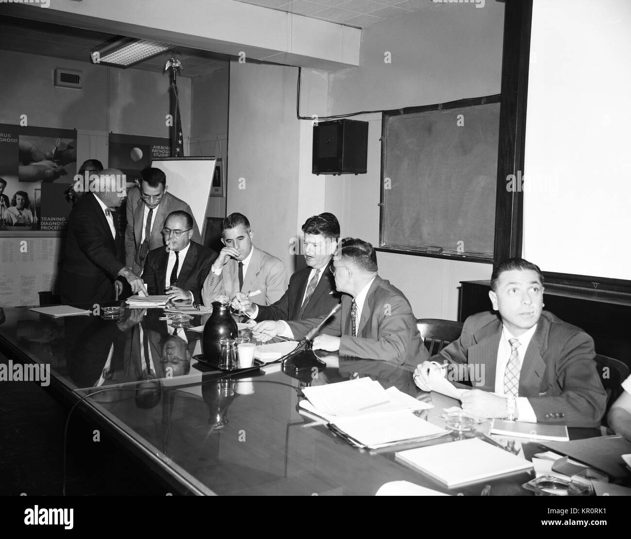 This 1956 photograph depicts a number of CDC officials during a bid opening meeting for the construction of new CDC facilities, 1956. Various governmental contracts are governed by established protocols, which often include a bidding process amongst interested parties. Image courtesy CDC. Stock Photo