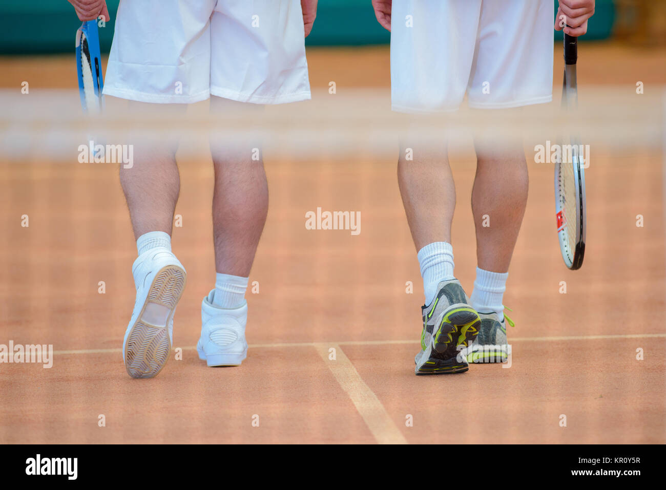 View of two men's legs on tennis court Stock Photo