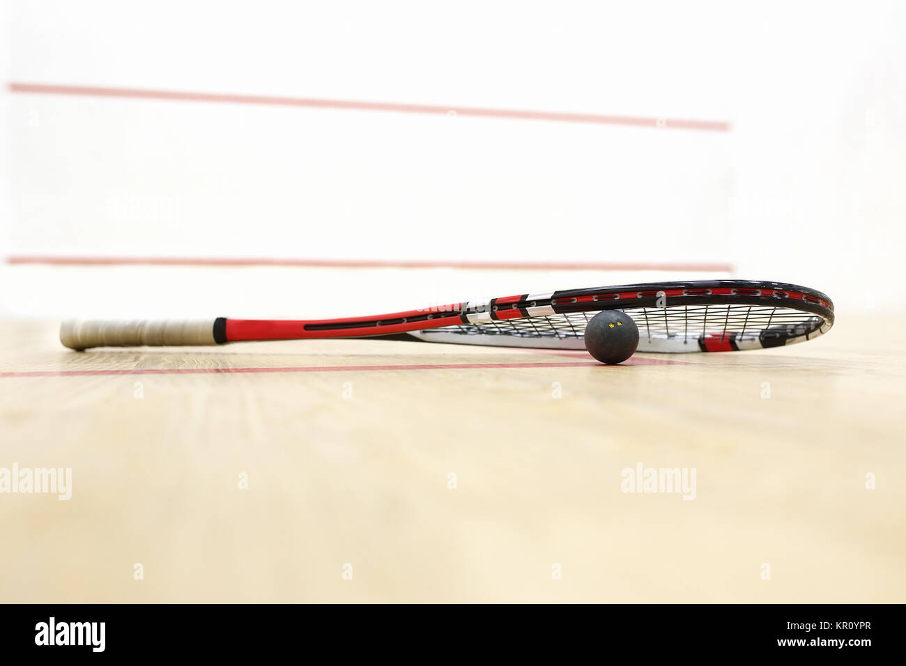 squash racket and ball on the wooden floor. Racquetball equipment on