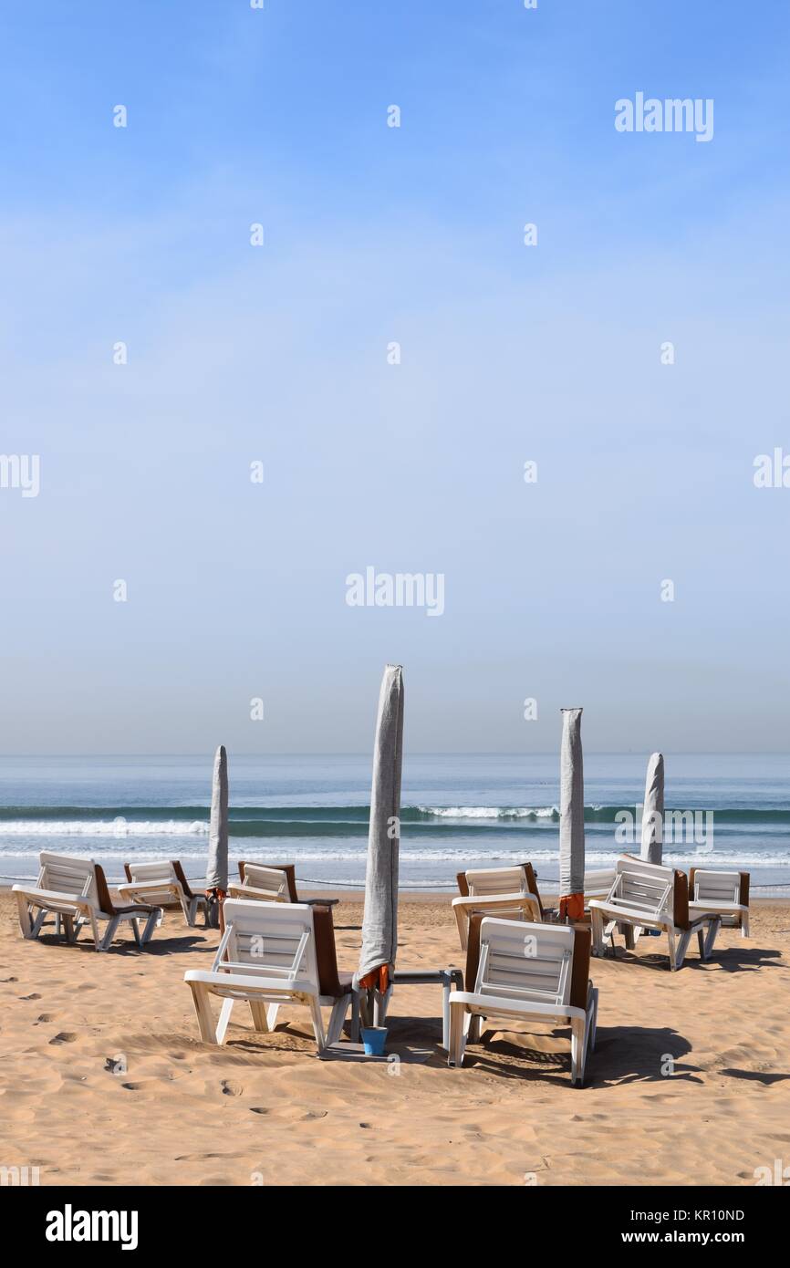 sunbeds,umbrellas and footprints on an empty beach Stock Photo Alamy