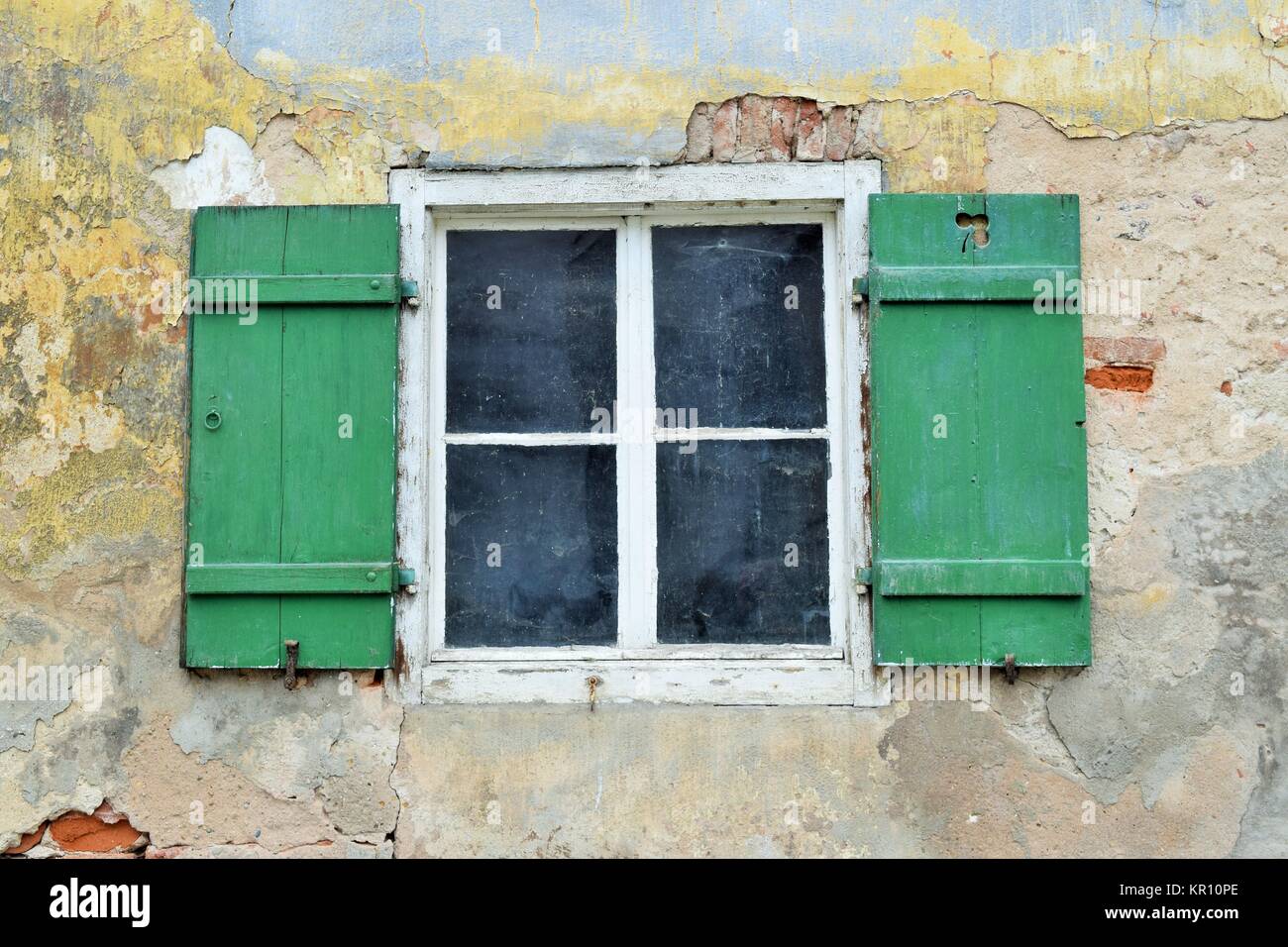 old wooden windows with shutters open in a dilapidated house in need of