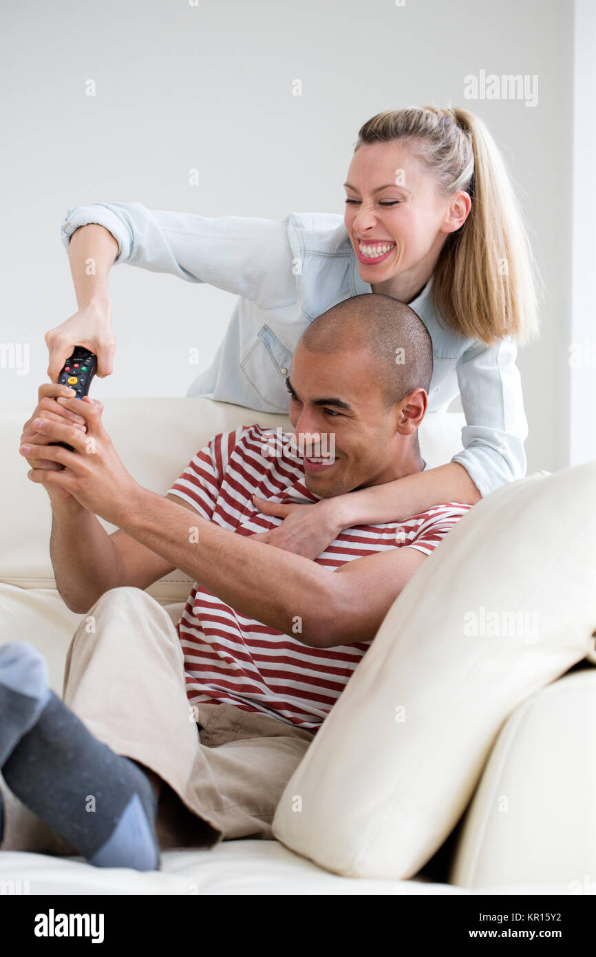 Couple Fighting Over TV Remote Stock Photo