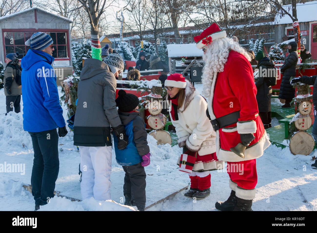 Montreal, Canada - 16 December 2017: Santa Claus and Mother Christmas talking to a child at the 'Christmas in the park' festival Stock Photo