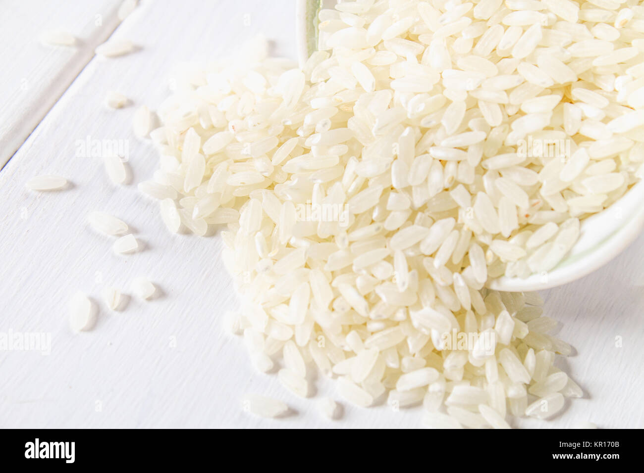 White Items Rice Grains of raw white rice on a white wooden table of boards. Ingredients ...