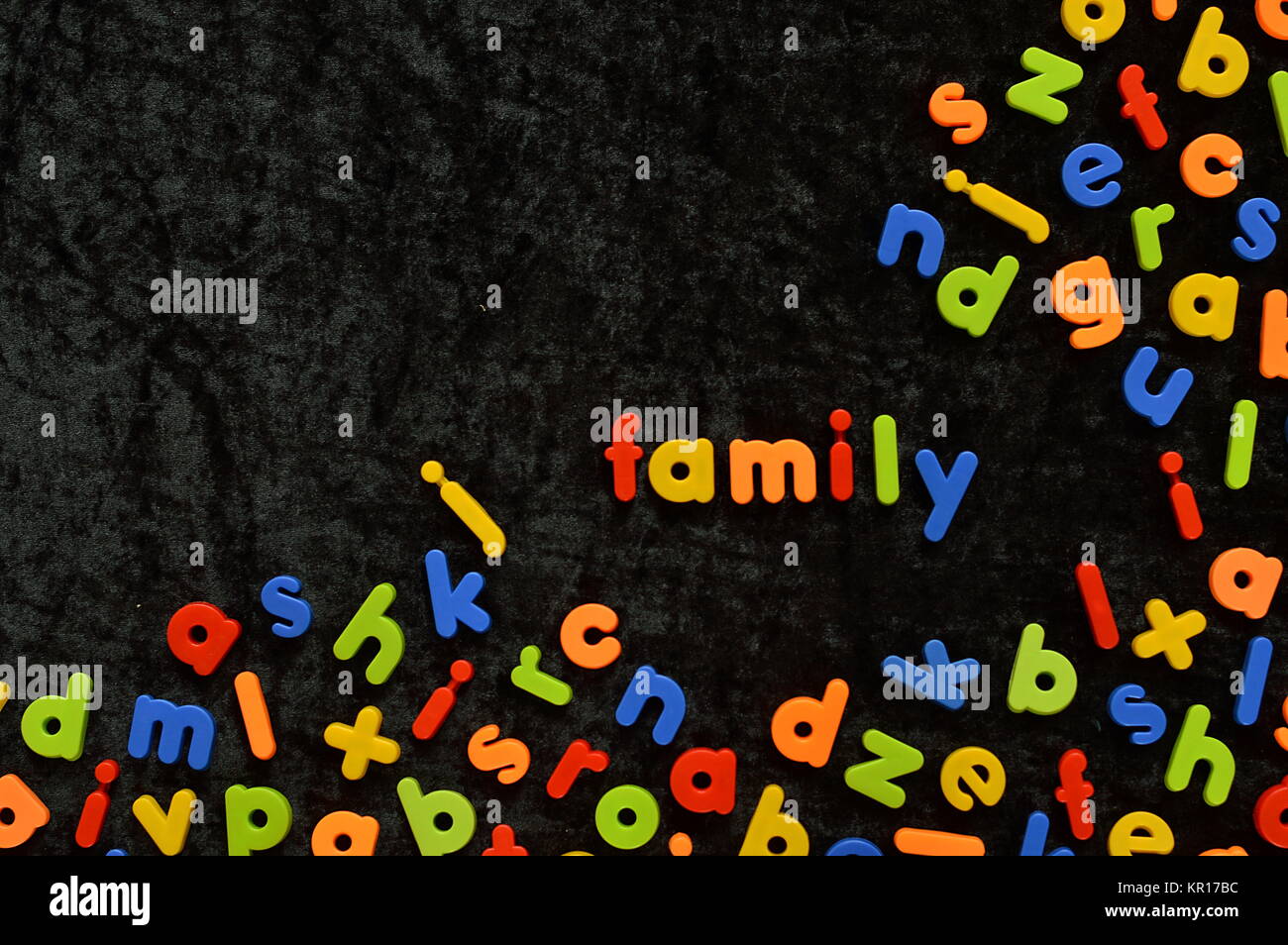 the word FAMILY written with colorful magnetic letters on black ground Stock Photo