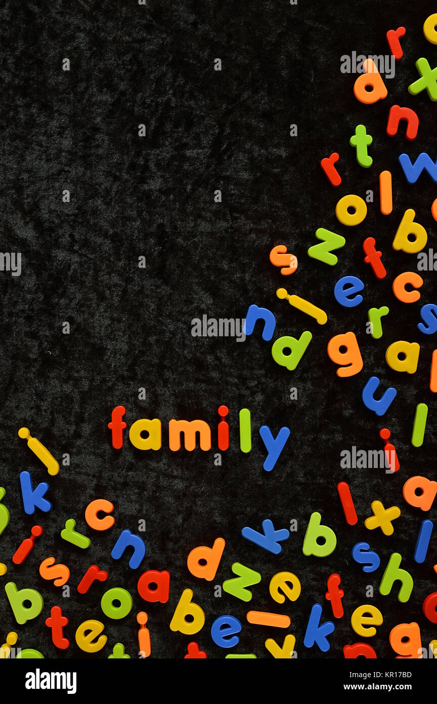 the word FAMILY written with colorful magnetic letters on black ground Stock Photo