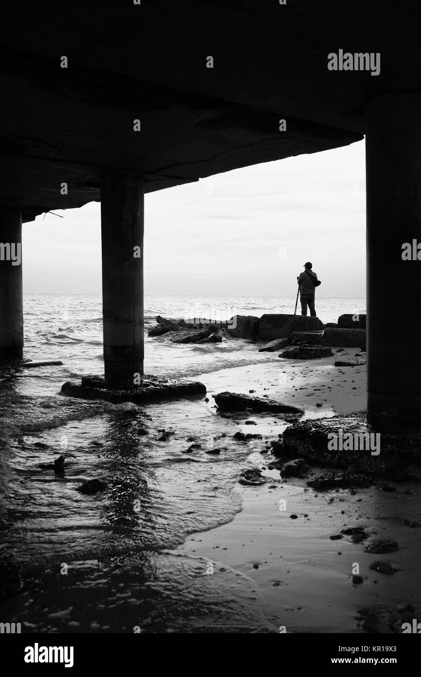 Man standing on beach taking photos, Mahboula, Ahmadi, Kuwait Stock Photo