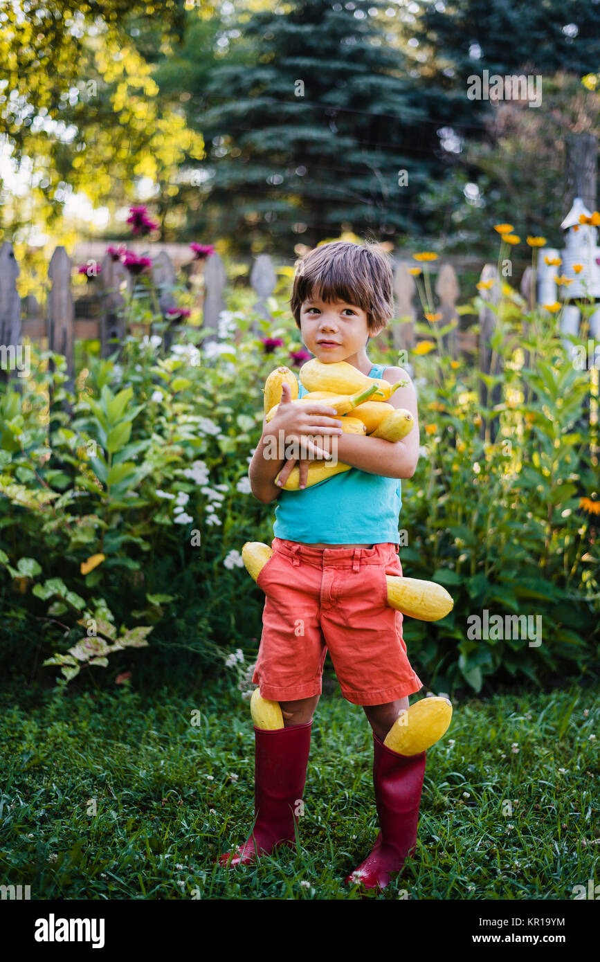 Boy carrying fresh harvest of summer squash Stock Photo