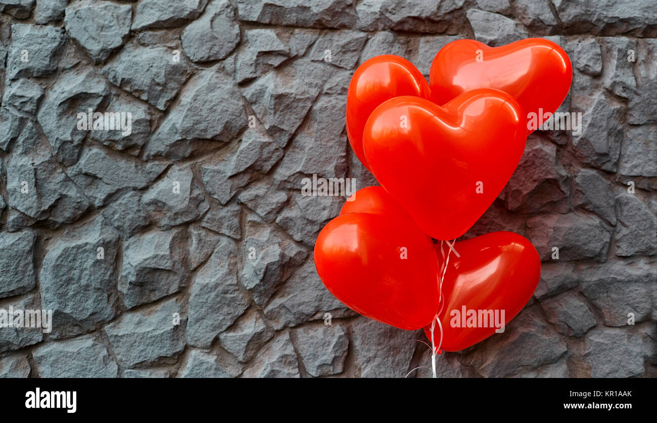 Red balloon heart on a background of gray stone.  Stock Photo