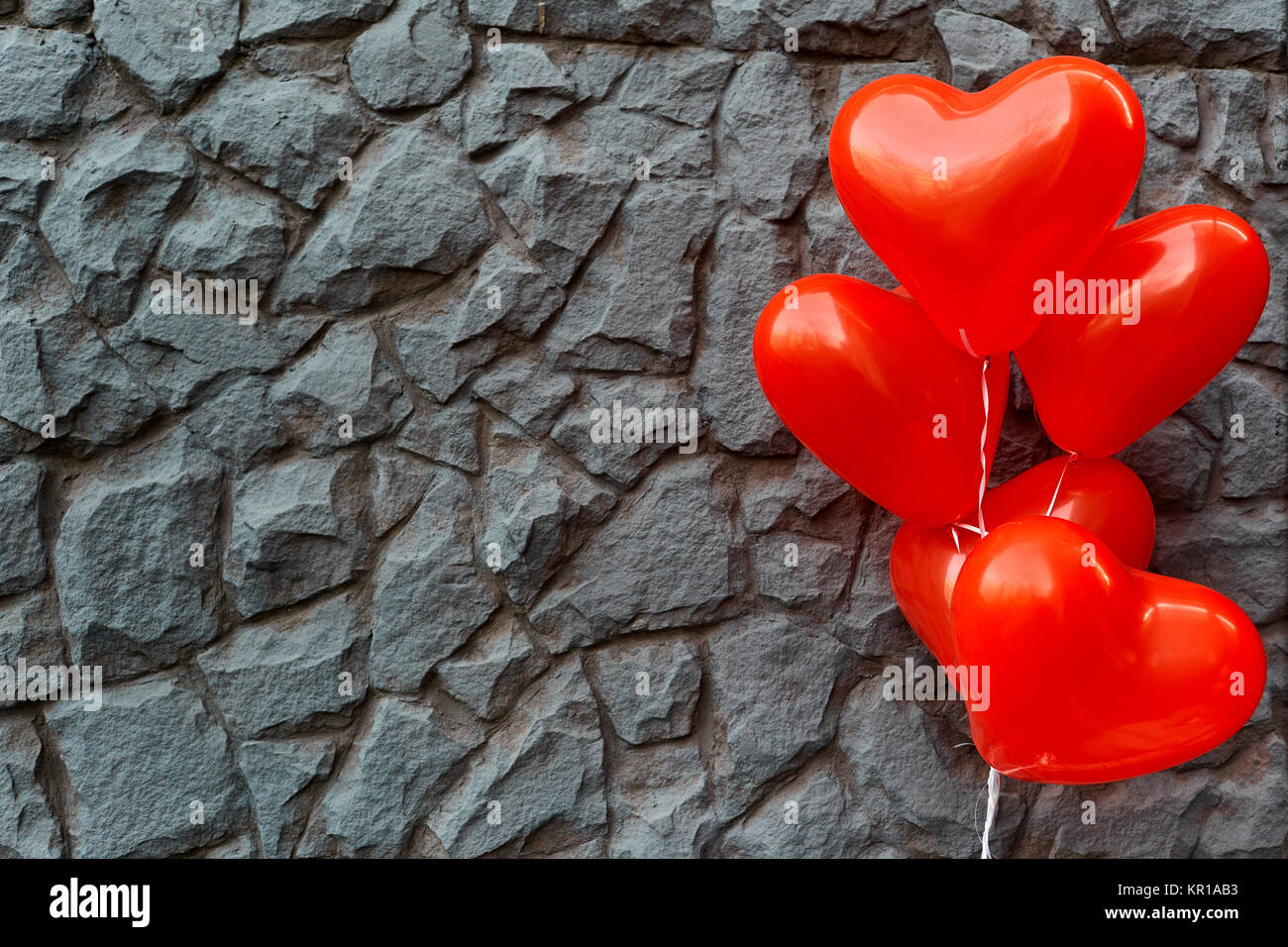 Red balloon heart on a background of gray stone.  Stock Photo