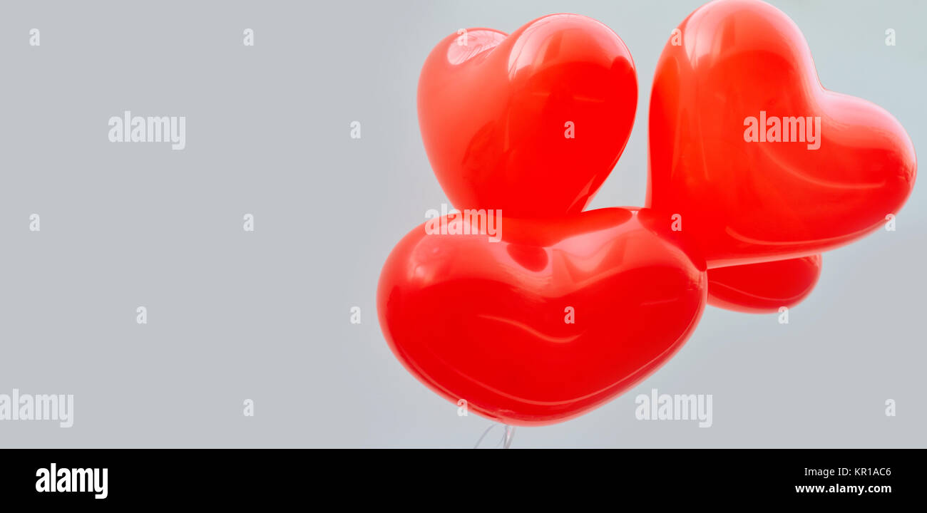 Balloons red heart on a white wall background Stock Photo - Alamy