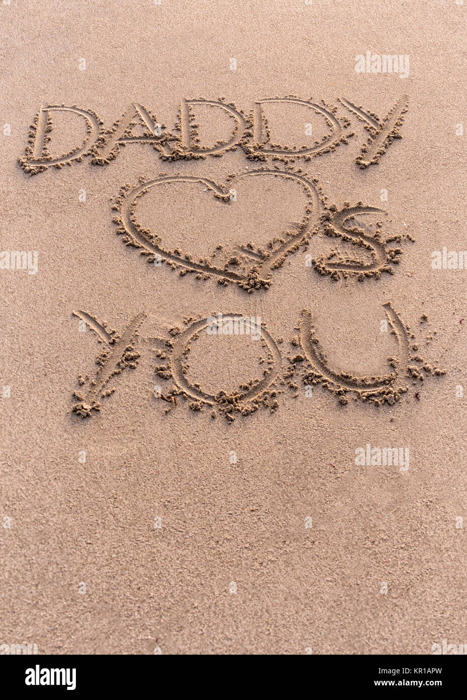 Daddy Loves You written in sand on the beach Stock Photo