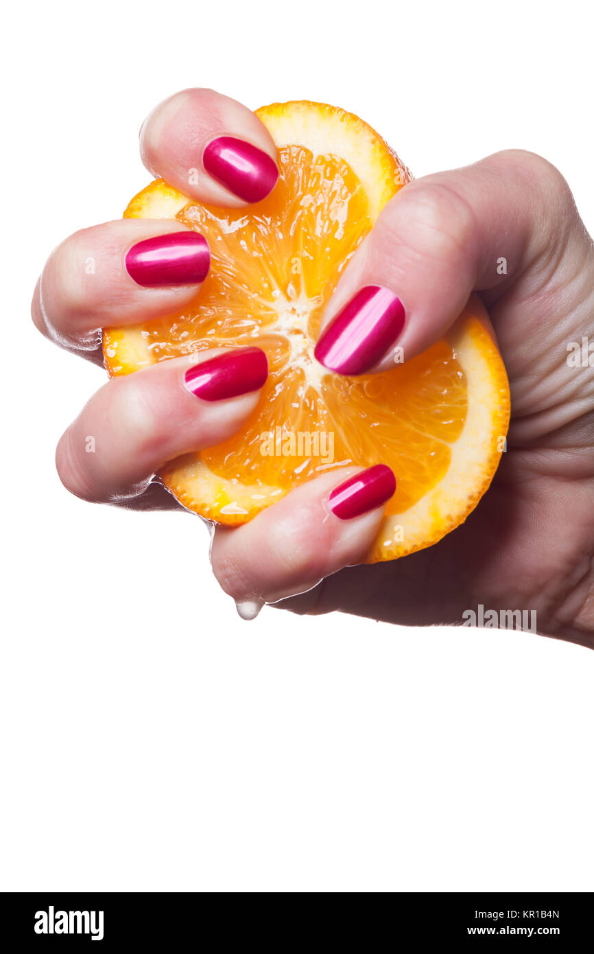 Hand mit gepflegten Fingernägeln und Orange Nahaufnahme isoliert auf weißem Hintergrund Stock Photo