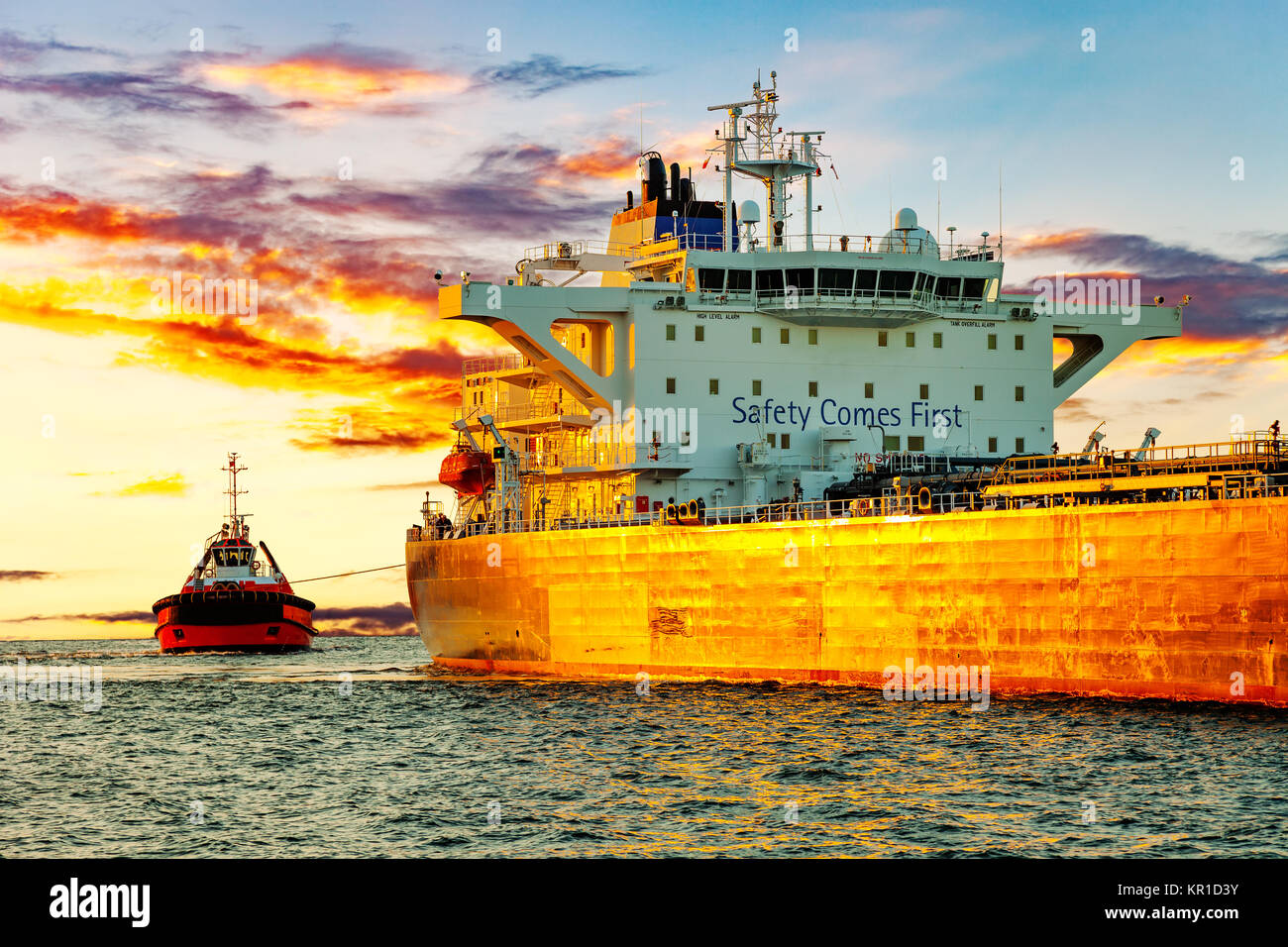 Tanker and tugboat on sea early morning just before sunrise. Stock Photo