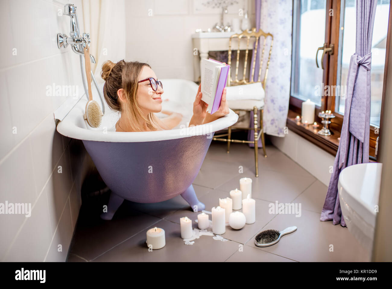 Woman reading book in the bathroom Stock Photo Alamy
