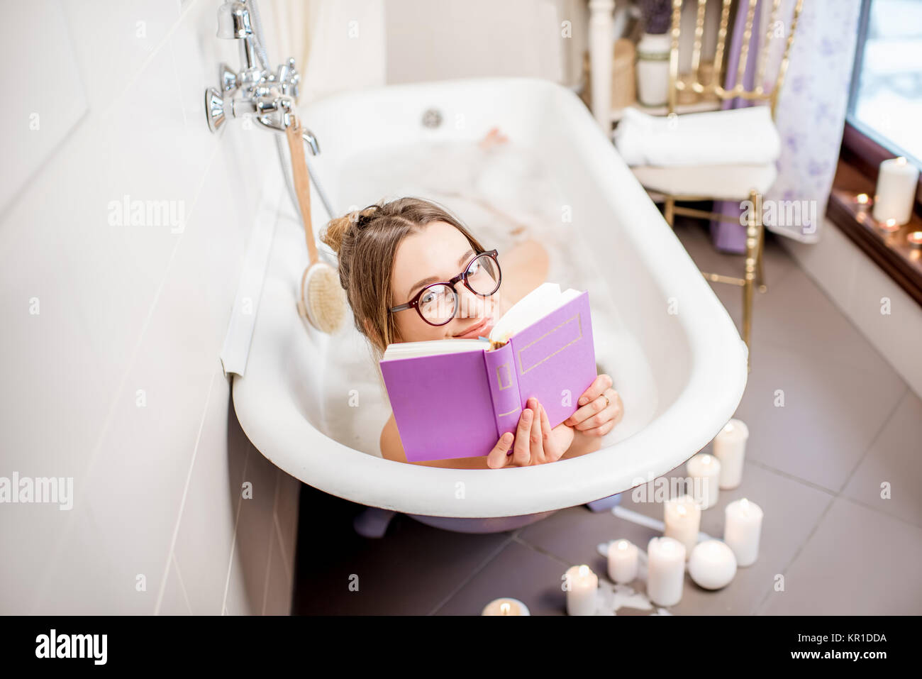 Woman reading book in the bathroom Stock Photo Alamy