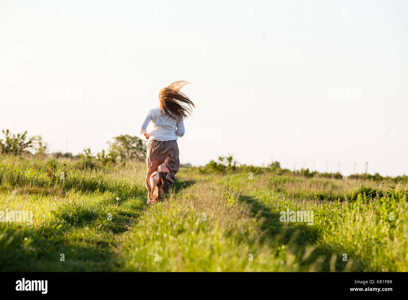 The girl ran across the field Stock Photo - Alamy