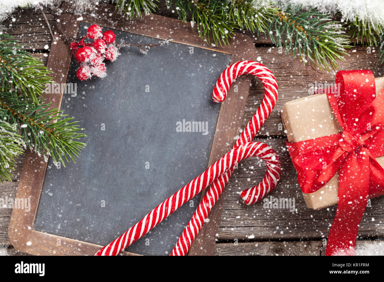 Christmas gift box, candy cane and snow fir tree on wooden table. Top ...
