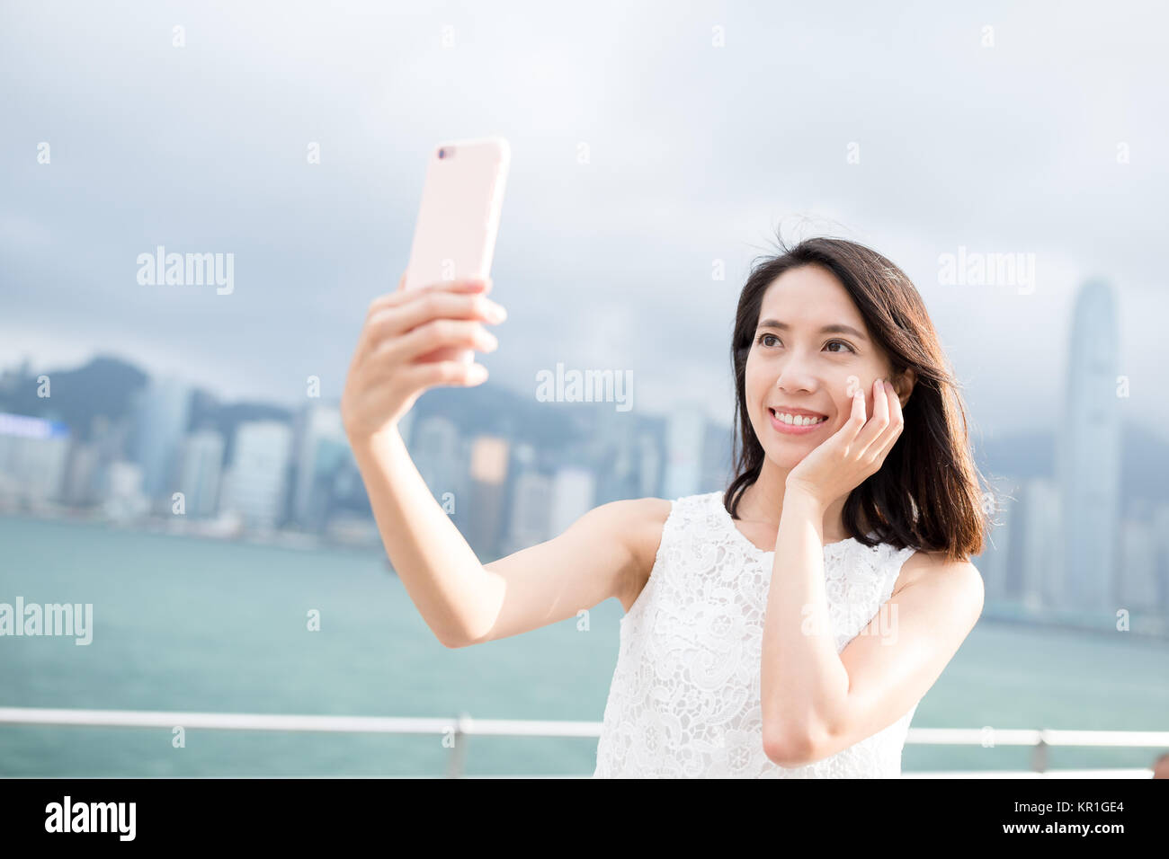 Woman taking photo with smart phone in Hong Kong Stock Photo - Alamy