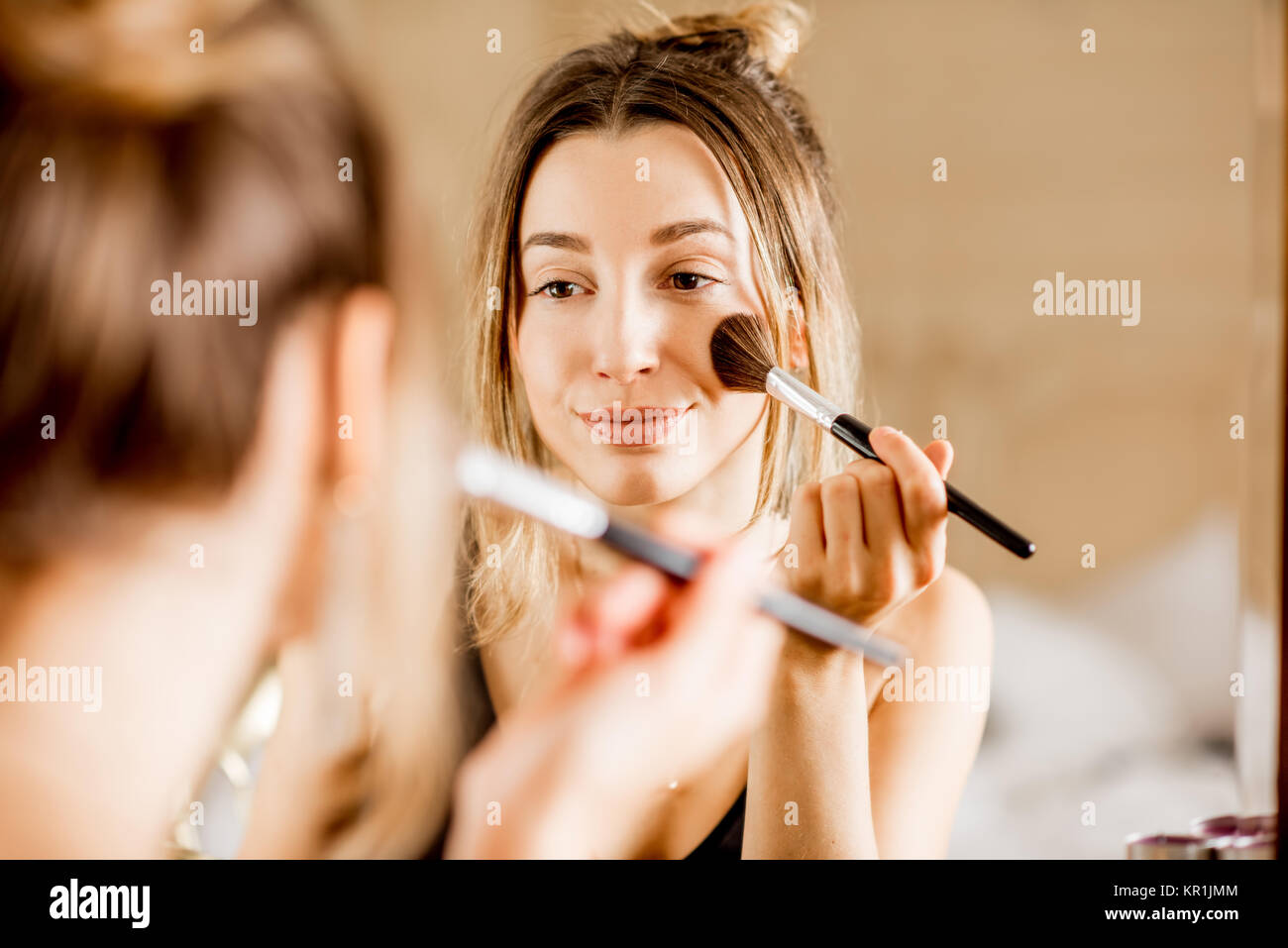Woman applying cosmetics Stock Photo
