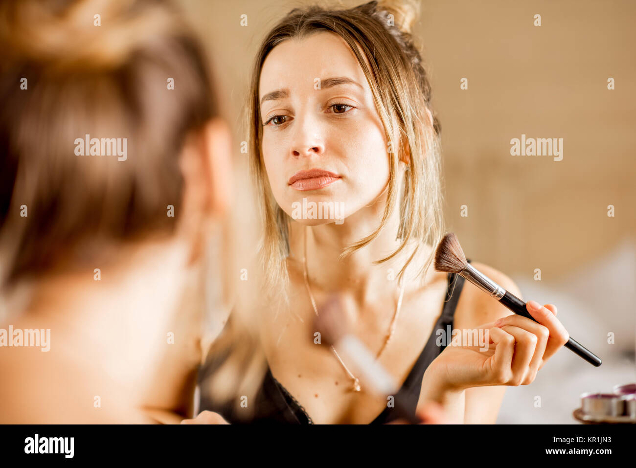 Woman applying cosmetics Stock Photo