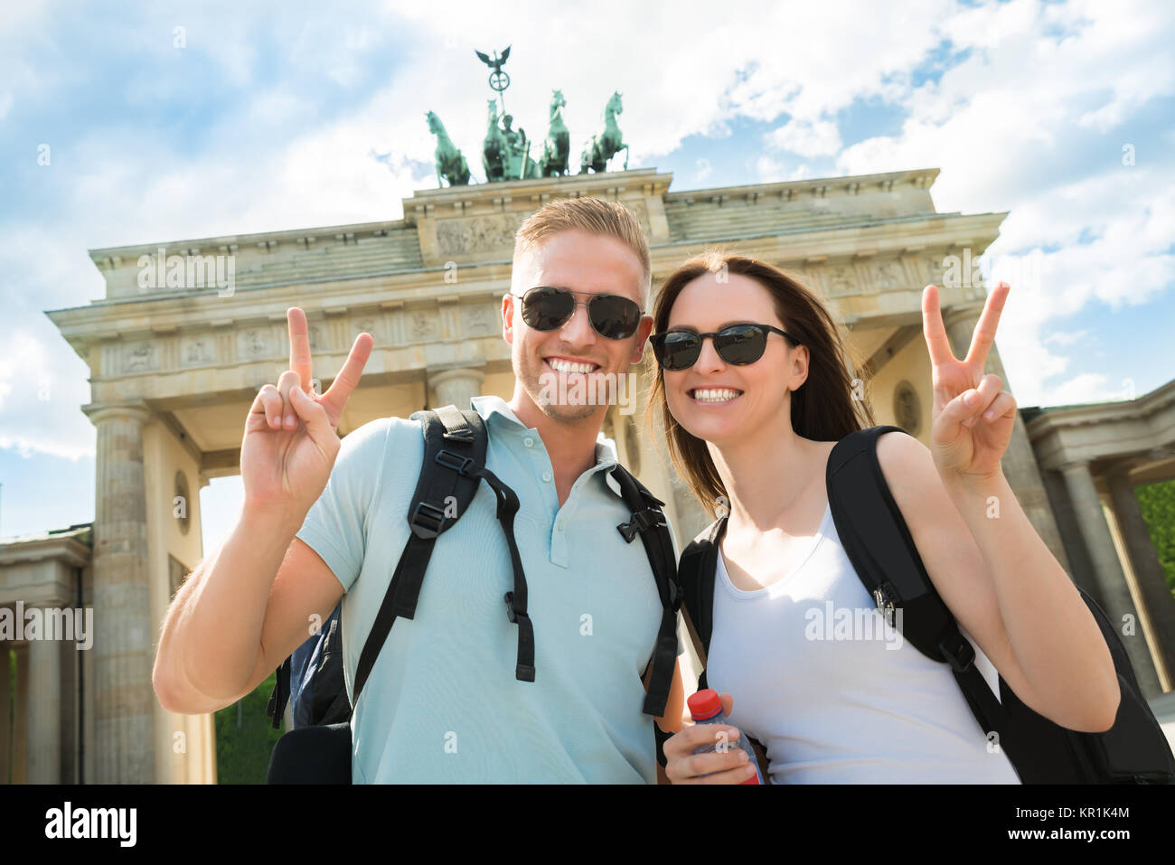 Happy Couple Making Peace Sign Stock Photo