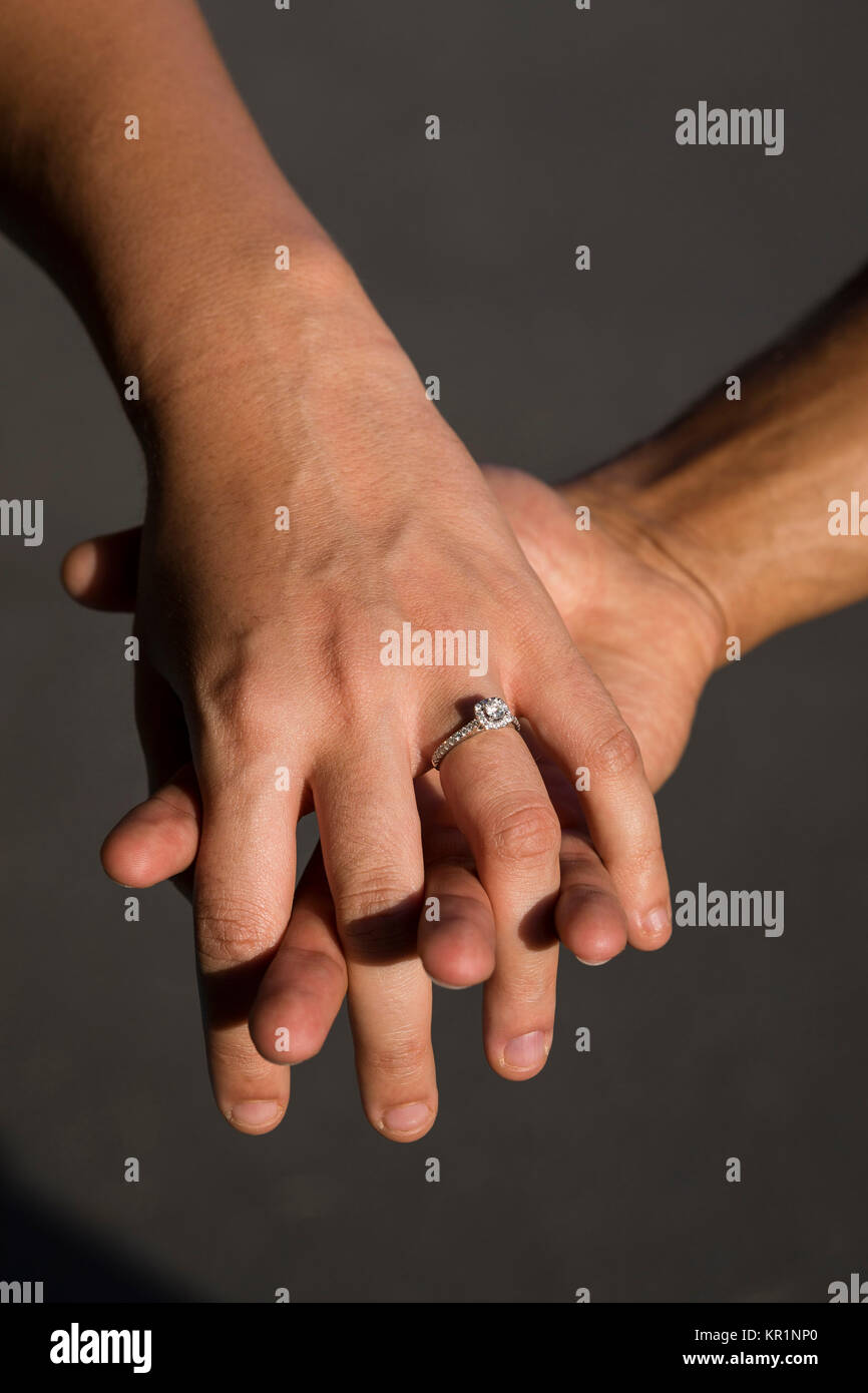 Engaged couple holding hands Stock Photo