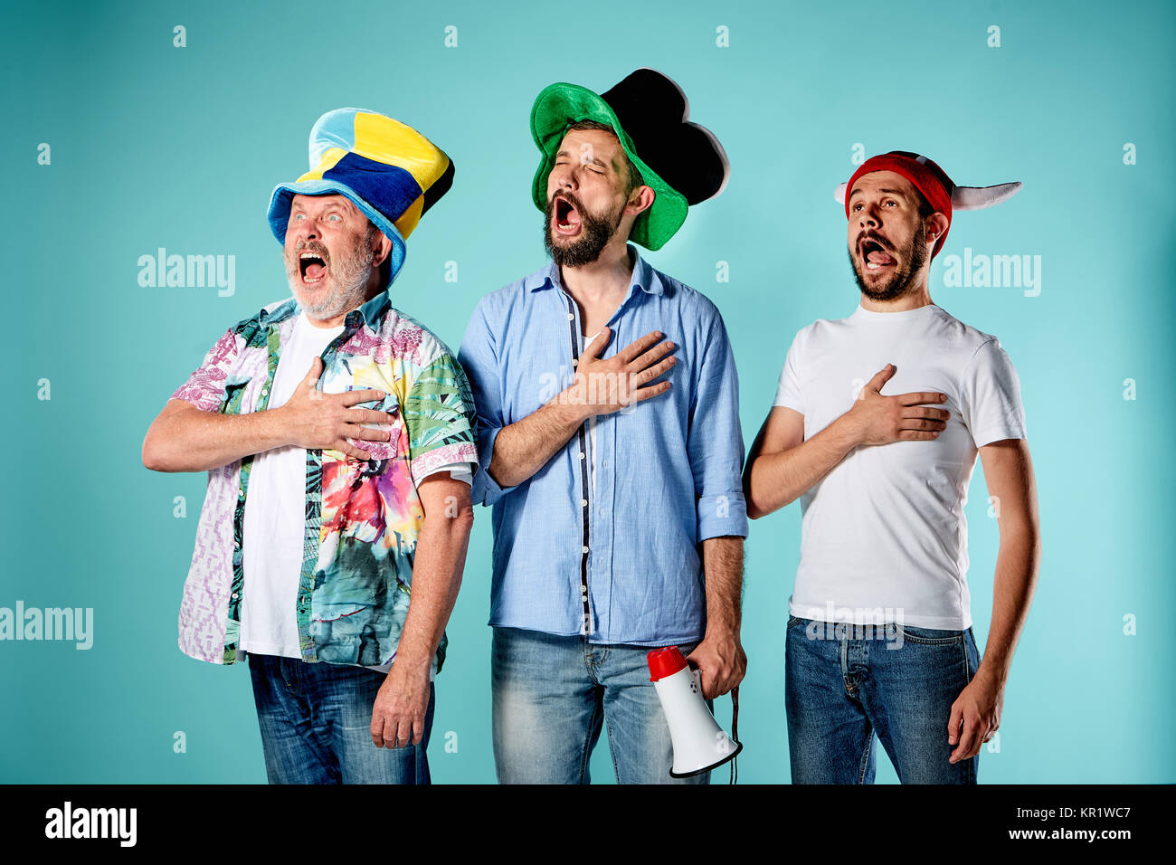 The three football fans singing the national anthem over blue Stock