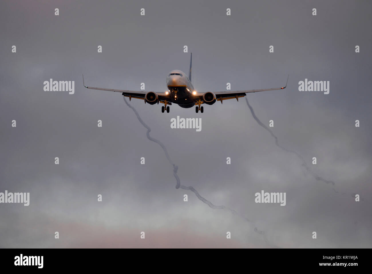 Ryanair Boeing 737 airliner jet plane landing at London Stansted Airport at dusk. Vortices condensation streaming from the wing flaps Stock Photo