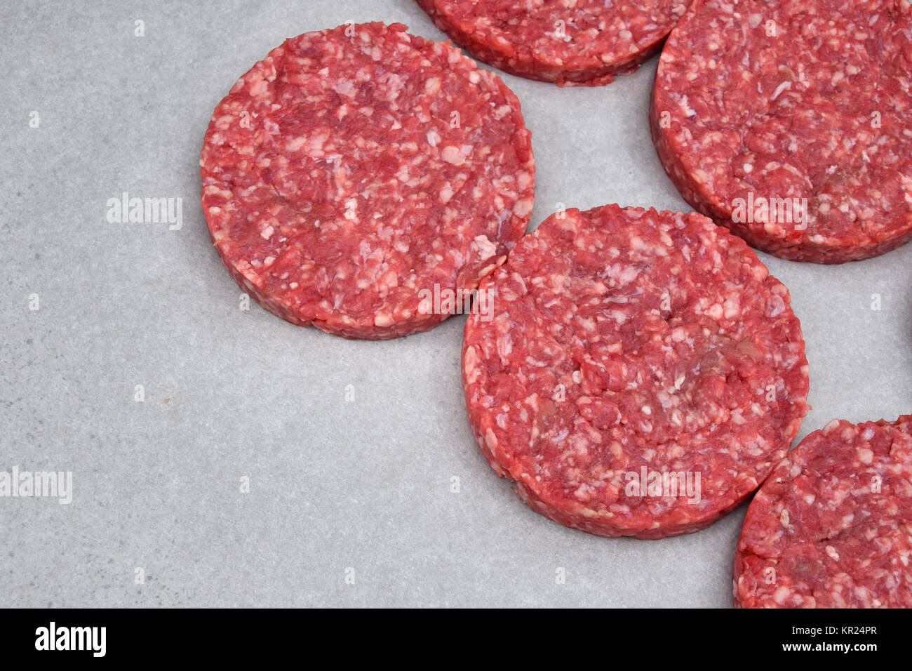 Raw meat burgers for hamburgers on parchment Stock Photo