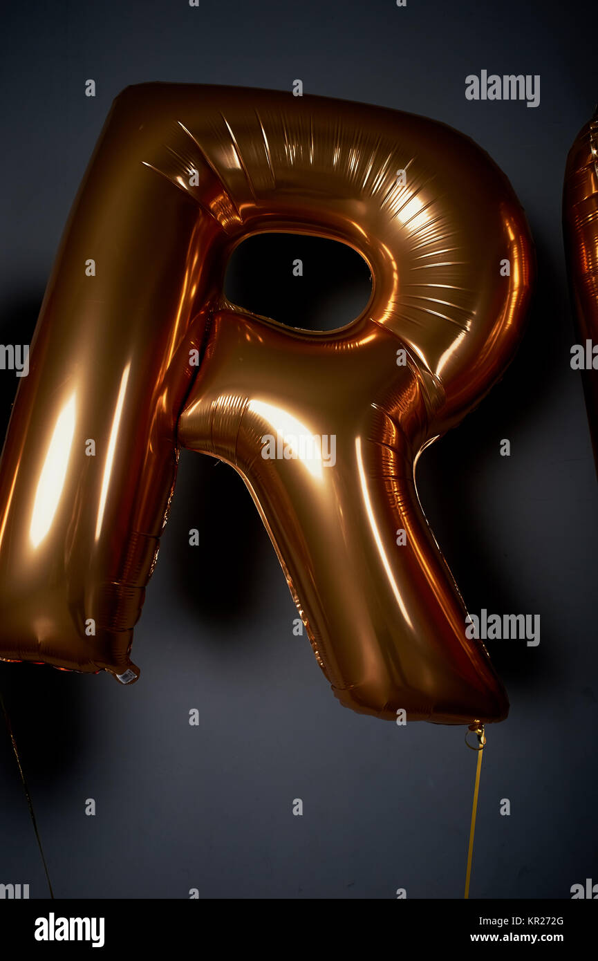 Golden balloons in the form of letters. The letter R. the Atmosphere of ...