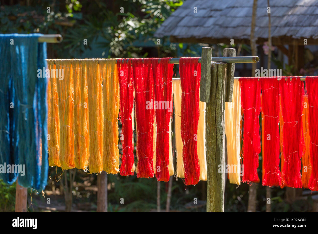 Colorful fabric hanging to dry after traditional dye processshot in Luang Prabang, Laos Stock Photo
