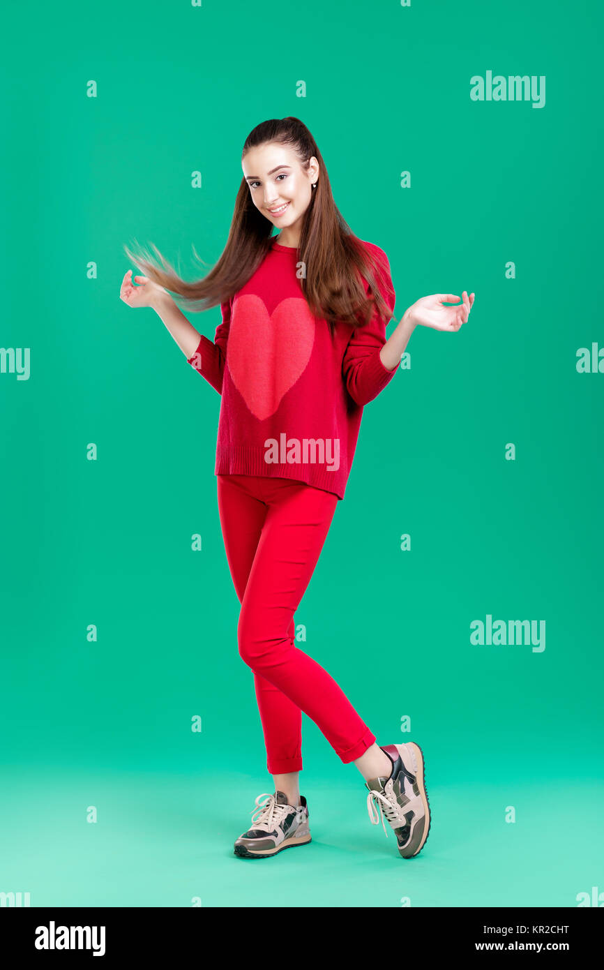 woman in red sweater on green background Stock Photo - Alamy