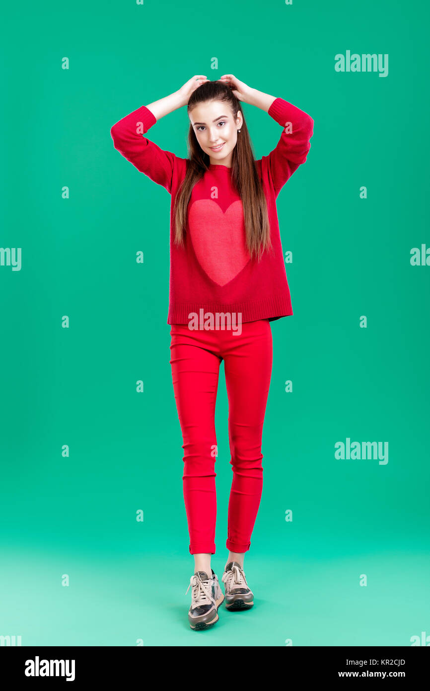 woman in red sweater on green background Stock Photo - Alamy