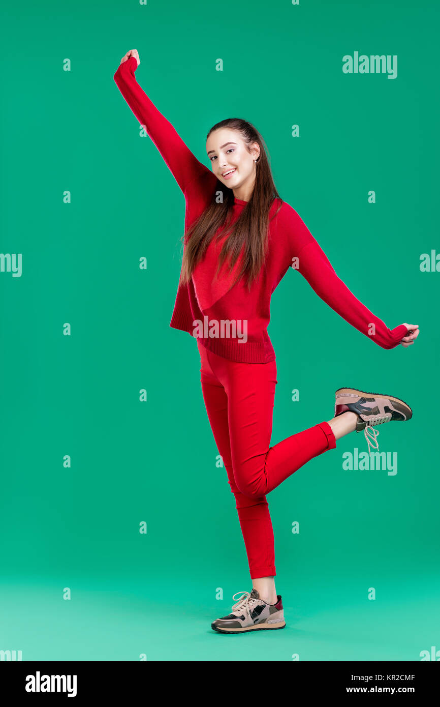 woman in red sweater on green background Stock Photo - Alamy
