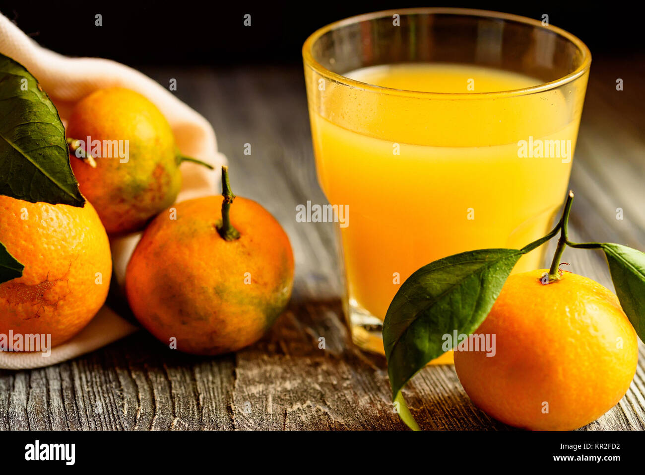 Glass of fresh juice and mandarins on table Stock Photo