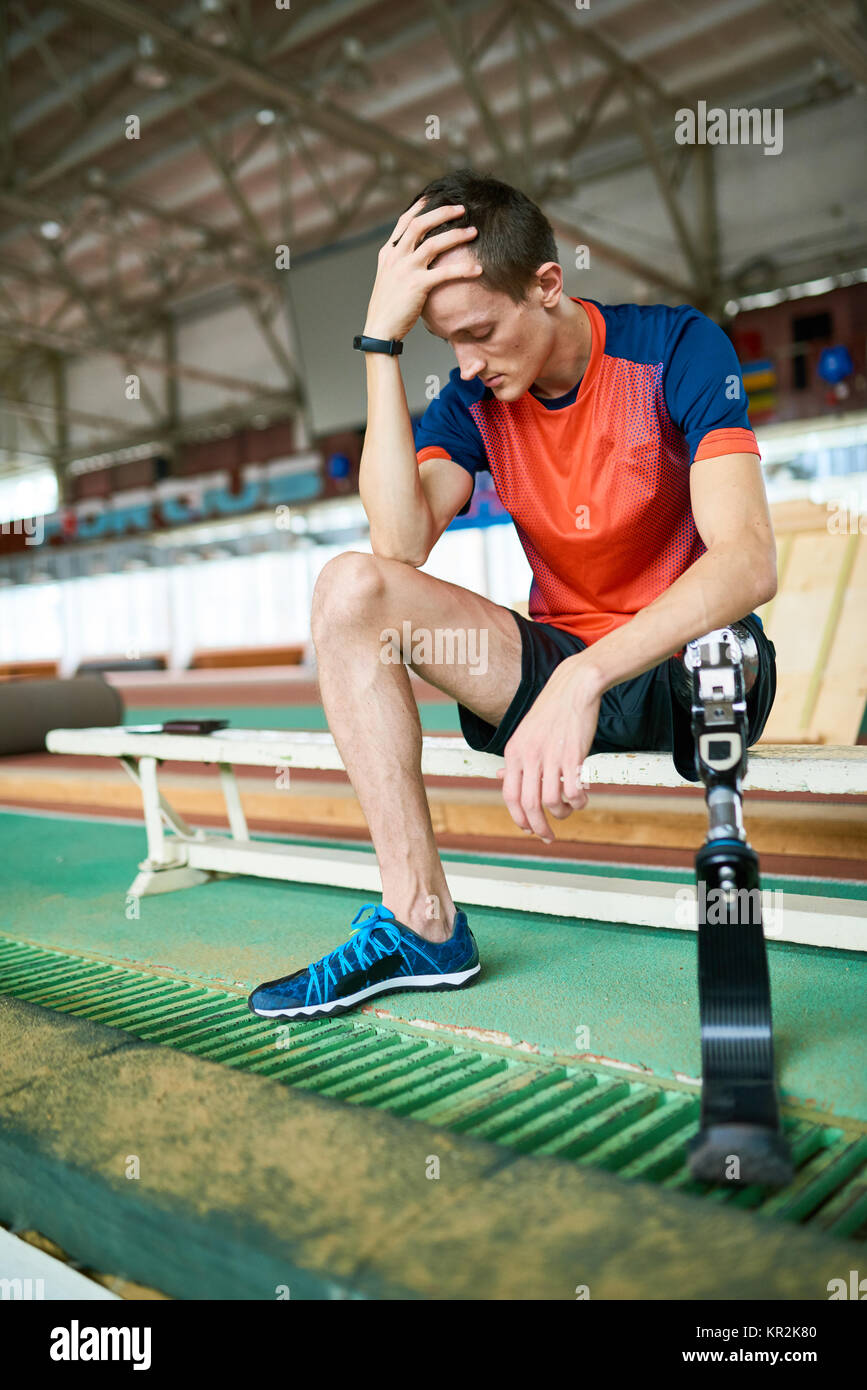 Handicapped Sportsman Sitting on Bench in Gym Stock Photo