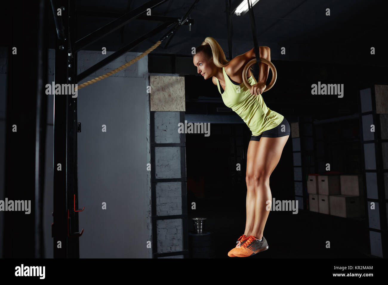 Horizontal shot of a female athlete performing ring dips exercise at