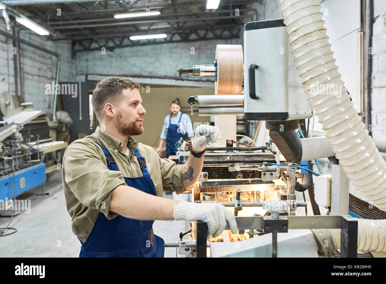 Young Worker Using Machine at Factory Stock Photo - Alamy