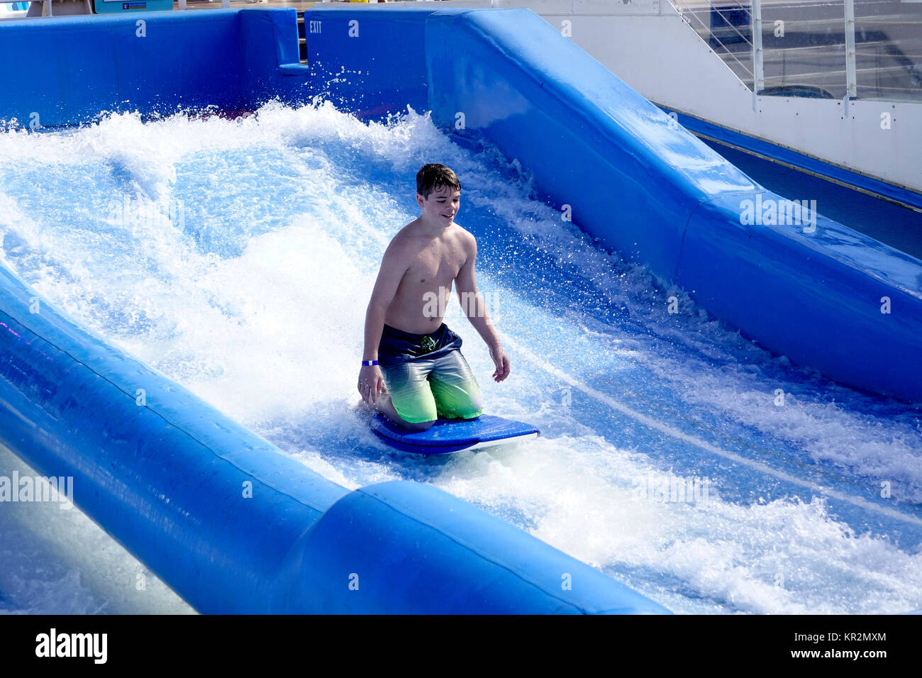 A young boy tries his luck on Royal Caribbean's Liberty of the Seas Flowrider amenity. Stock Photo