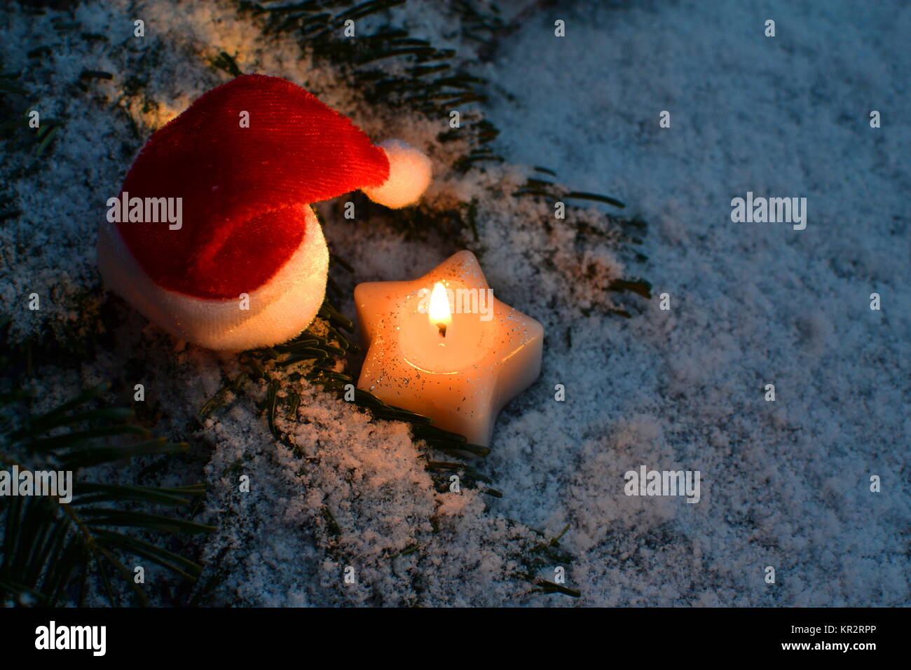 Santa claus has a dusk - space with a burning candle and snow outdoor Stock Photo