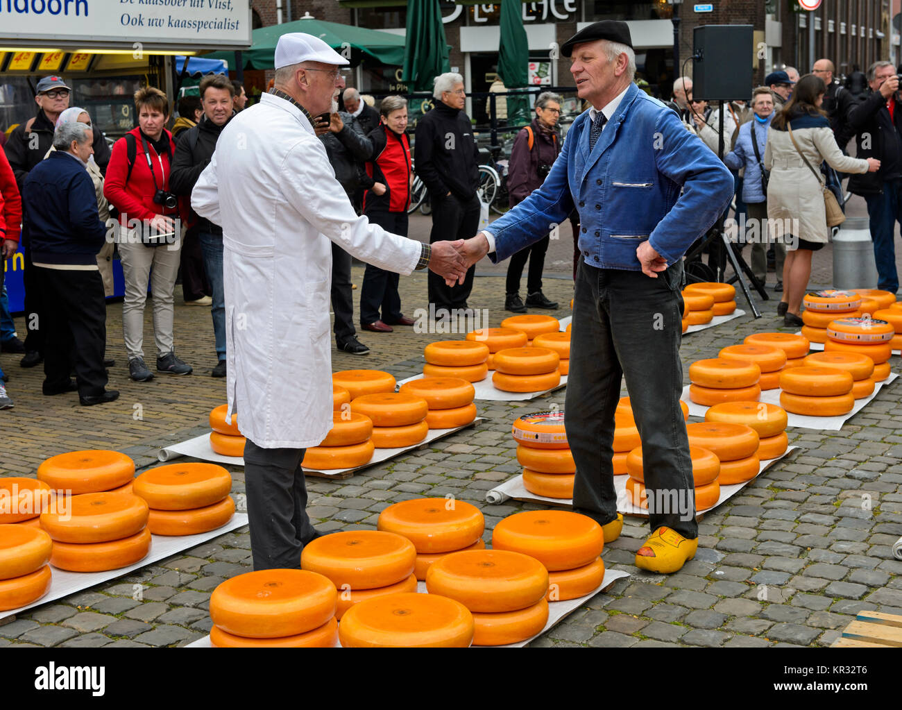 A cheese merchant, left, and a farmer, right, haggle over the price of