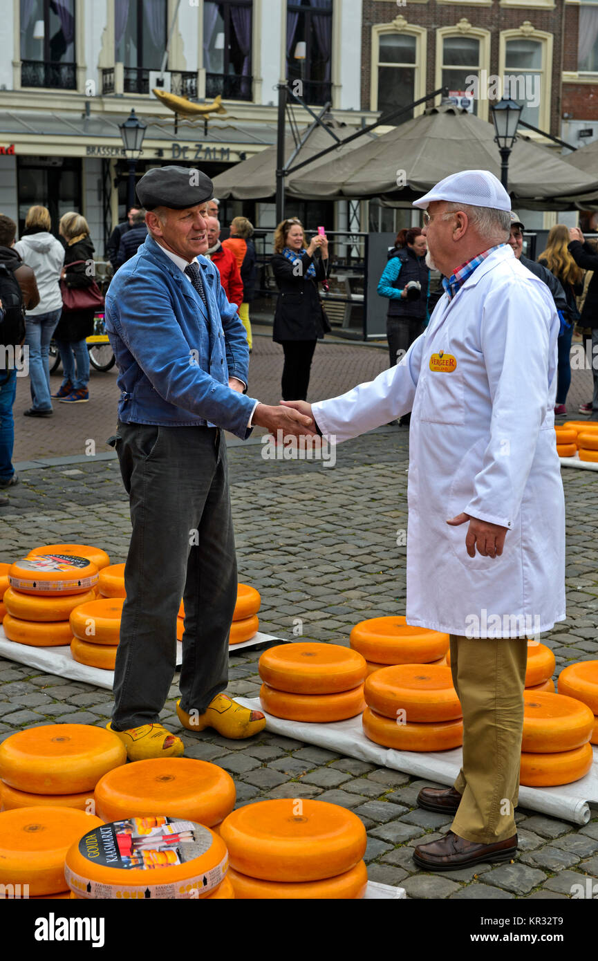 A farmer, left, and a cheese merchant, right, bargain over the price of Gouda cheese at the cheese market, Gouda, Netherlands Stock Photo