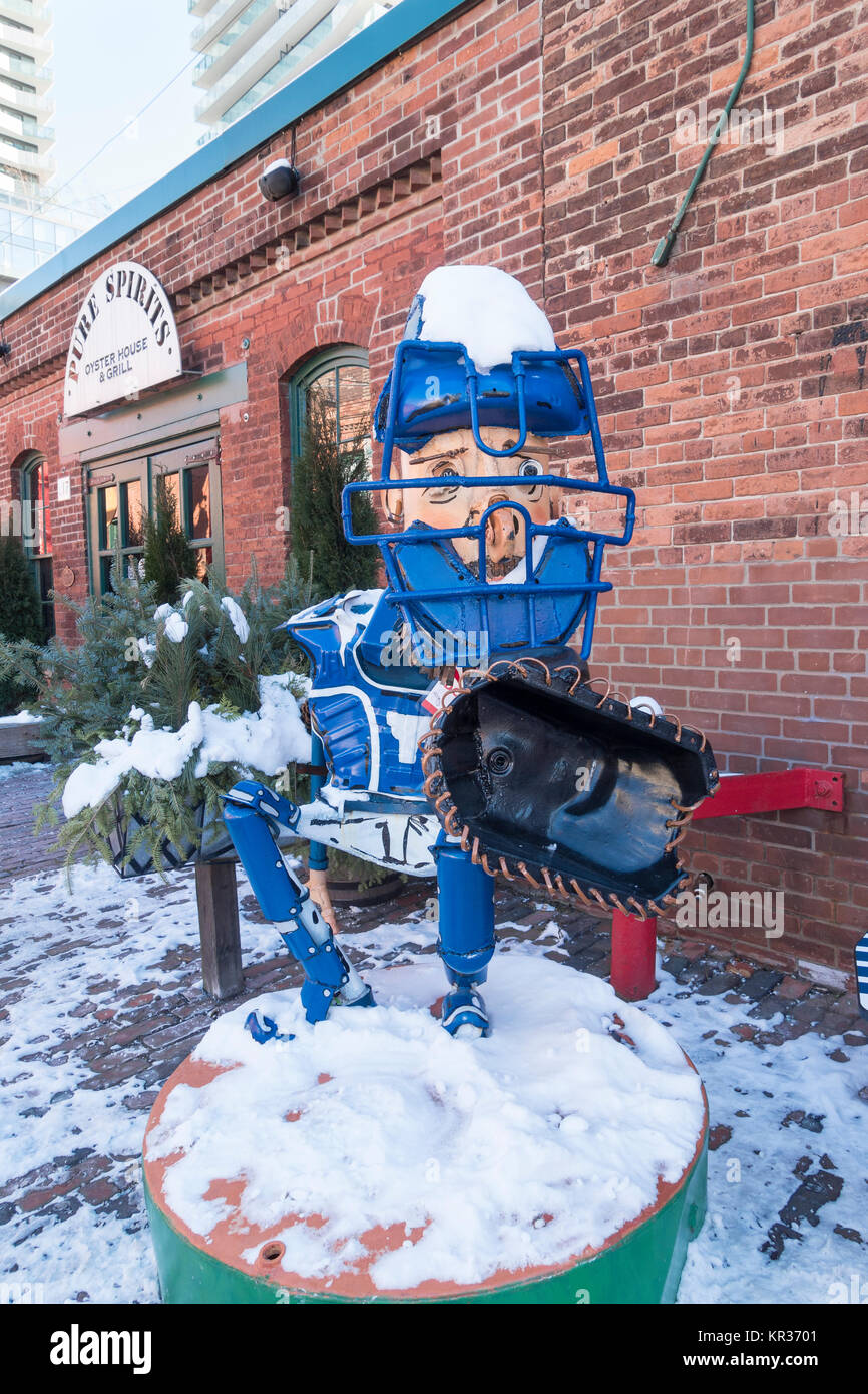 A 'junk art'  sculpture of a baseball catcher by Patrick Amiot on display in the Distillery district of Toronto Canada Stock Photo