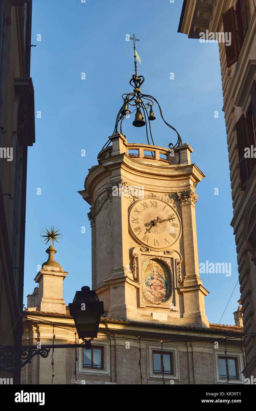 View from the street of the baroque bell tower with clock of a church in the historic center of Rome Stock Photo