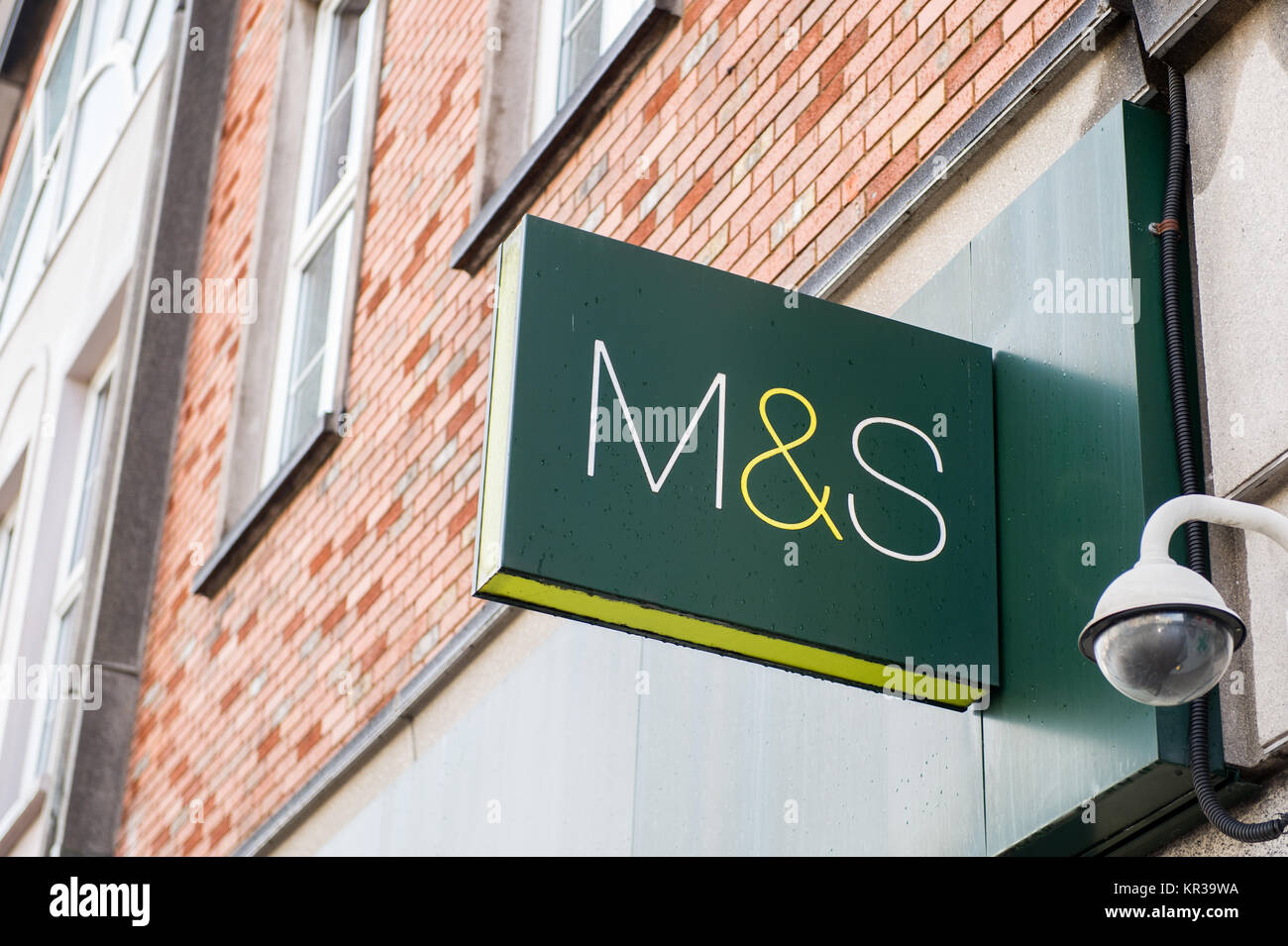 Marks & Spencer sign on a wall in Cork, Ireland with a CCTV camera and copy space. Stock Photo