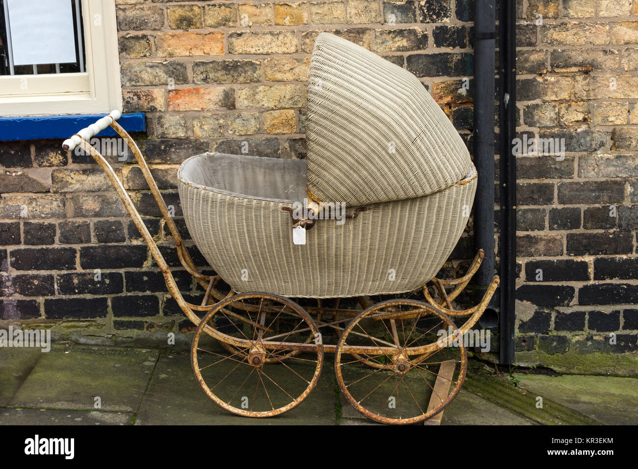 A vintage baby's pram outside an antiques shop on Steep Hill, Lincoln, England, UK Stock Photo