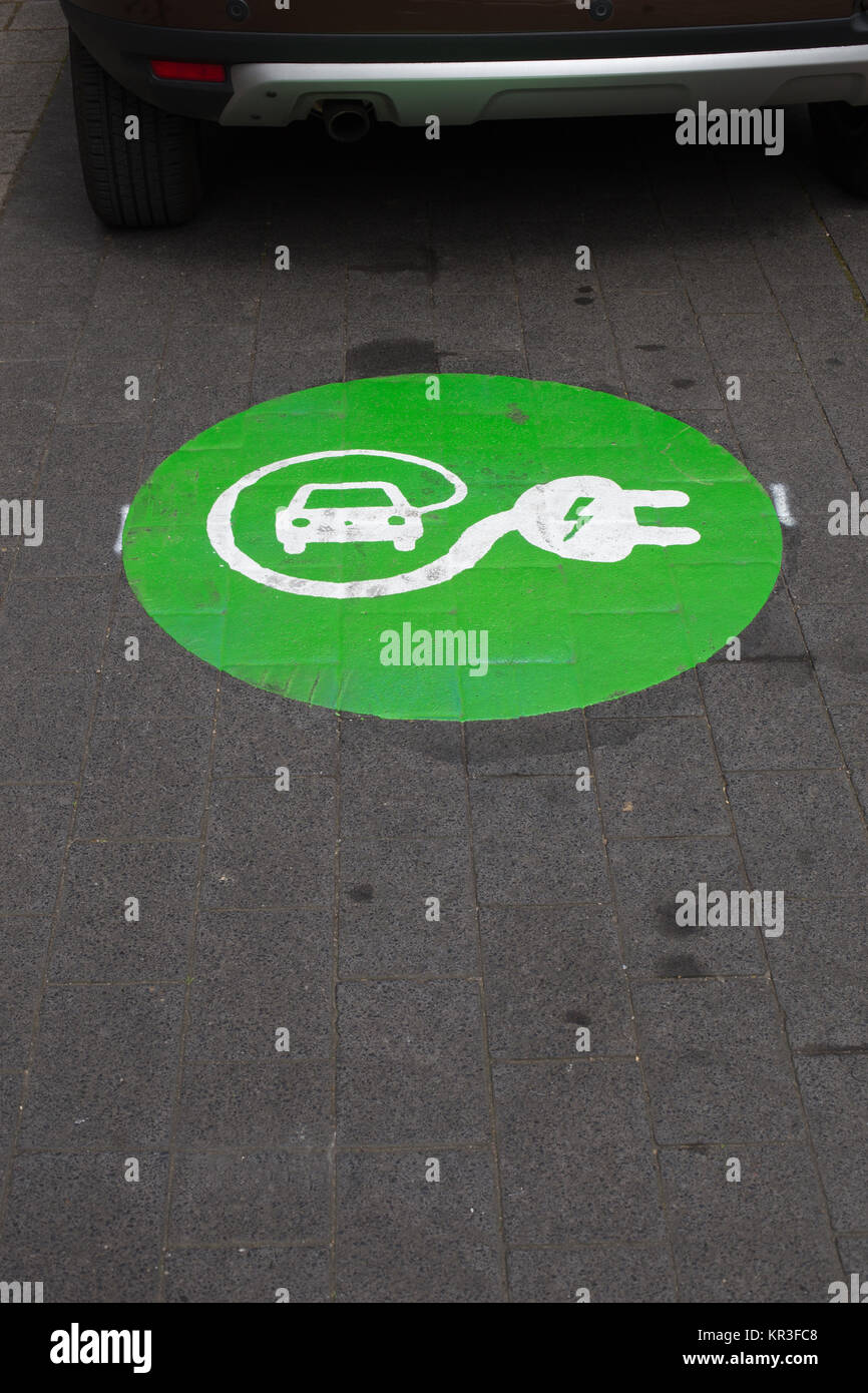 characters for a charging station for electric cars on asphalt Stock