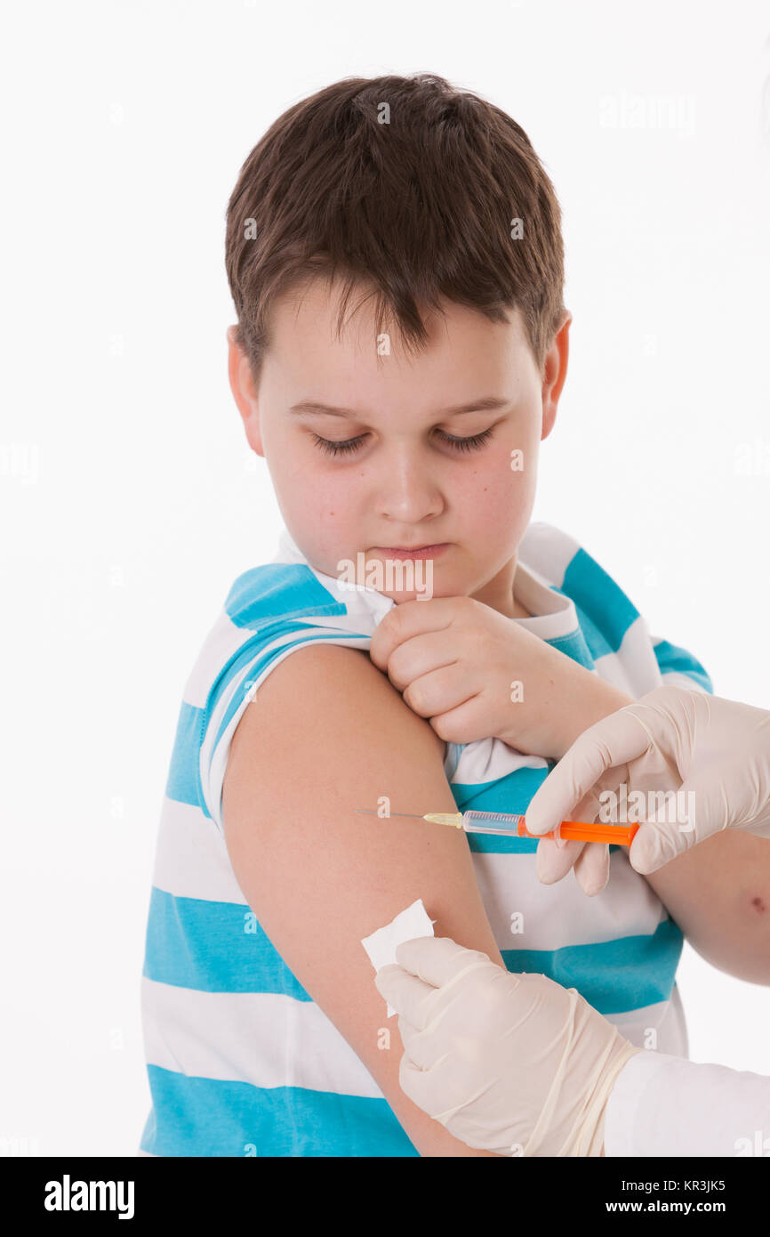 Doctor giving a child injection in arm on isolated image. Stock Photo